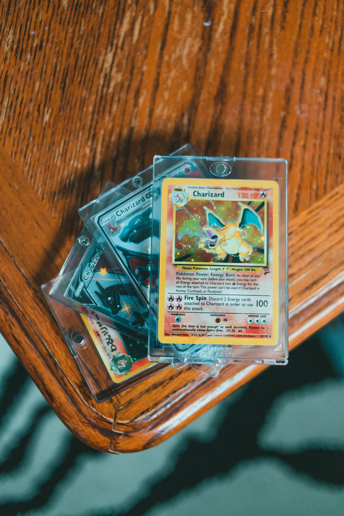 Premium close-up flat-lay of professional graded PSA 10 Charizard, Black Lotus, and Shiny Rayquaza cards